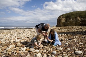 Family collecting pebbles on the beach at Blackhall